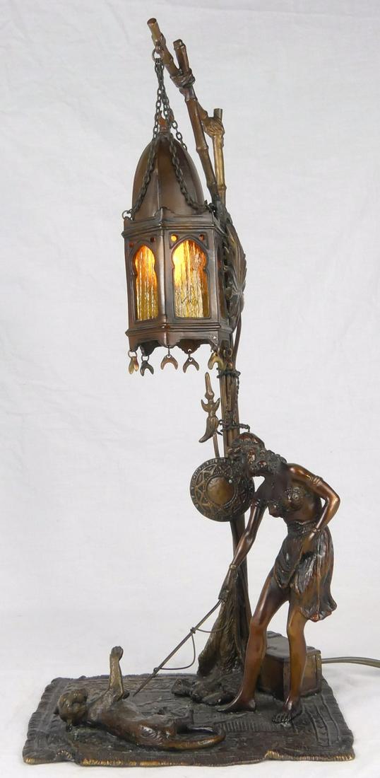 ANTON CHOTKA VIENNA BRONZE 'LION TAMER' LAMP: Anton Chotka (Austrian, 1881-1955) bronze lamp depicting a female lion tamer standing on a Persian carpet beneath a street lamp. Signed Chotka. Measures 17 1/2" height.