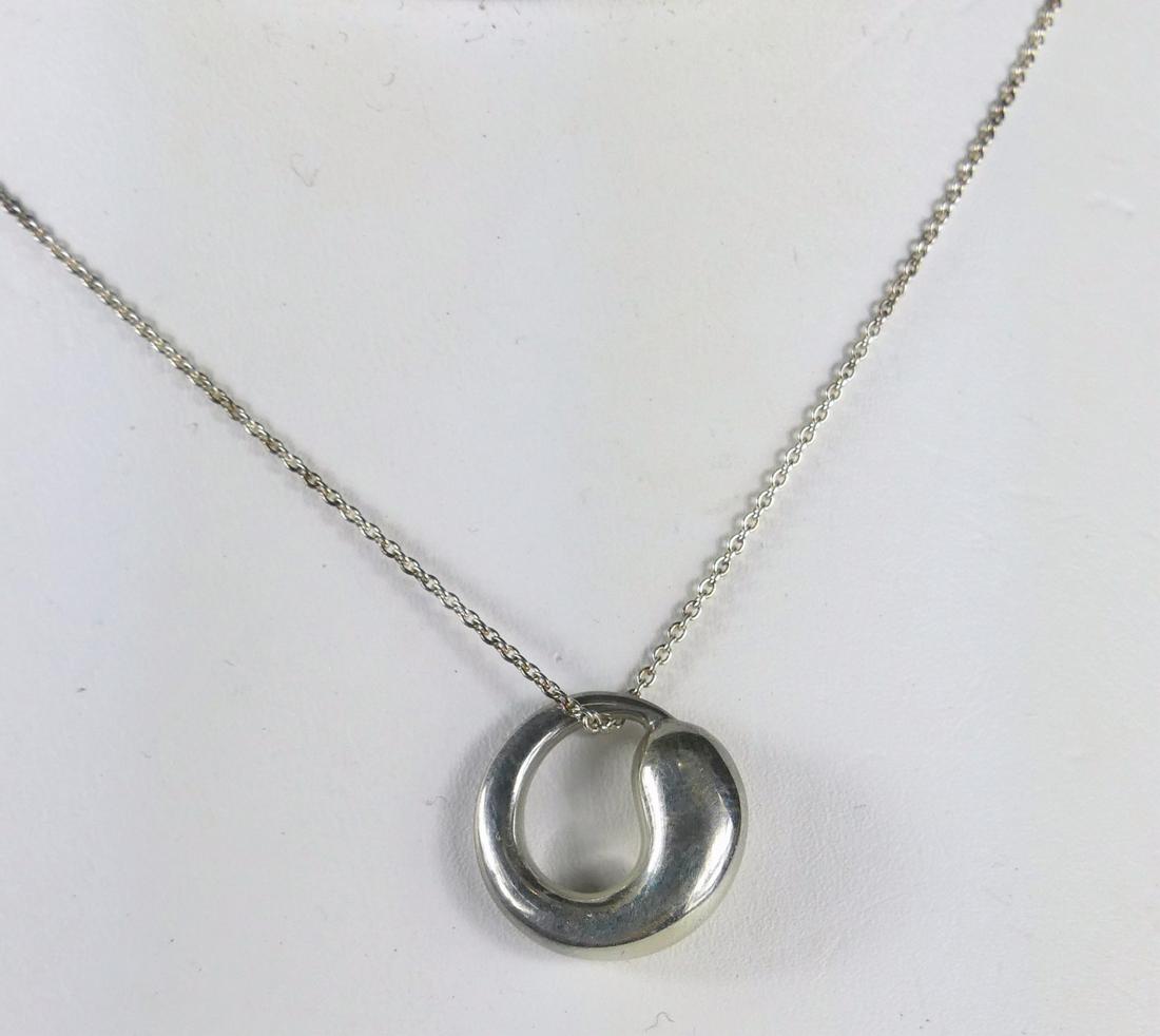 TIFFANY PERETTI ETERNAL CIRCLE PENDANT & CHAIN: Elsa Peretti for Tiffany & Company sterling silver Eternal Circle pendant and necklace. Pendant marked Tiffany & Co, Sterling, Peretti. Chain marked Peretti, Tiffany & Co. Pendant measures 16mm width.