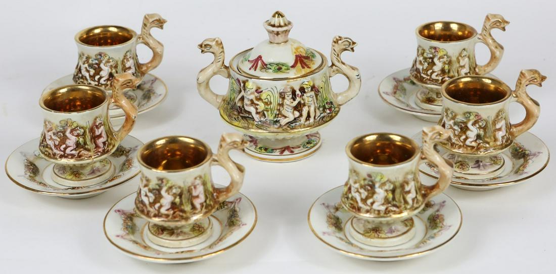 13pc CAPODIMONTE PORCELAIN DEMITASSE SET w BOX: 13 piece Capodimonte porcelain demitasse espresso set. Includes 6 cups-3", 6 saucers-4" and 1 covered sugar-5". Decorated with cherubs and florals. Each marked to underside.