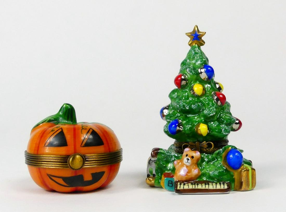 2pc LIMOGES HOLIDAY PORCELAIN TRINKET BOXES: 2 Limoges holiday theme porcelain trinket or pill boxes. Includes a Christmas tree with ornaments, star and gifts and Halloween Jack-o'-lantern. Tree marked to underside and measures 3 1/4" height. Pu