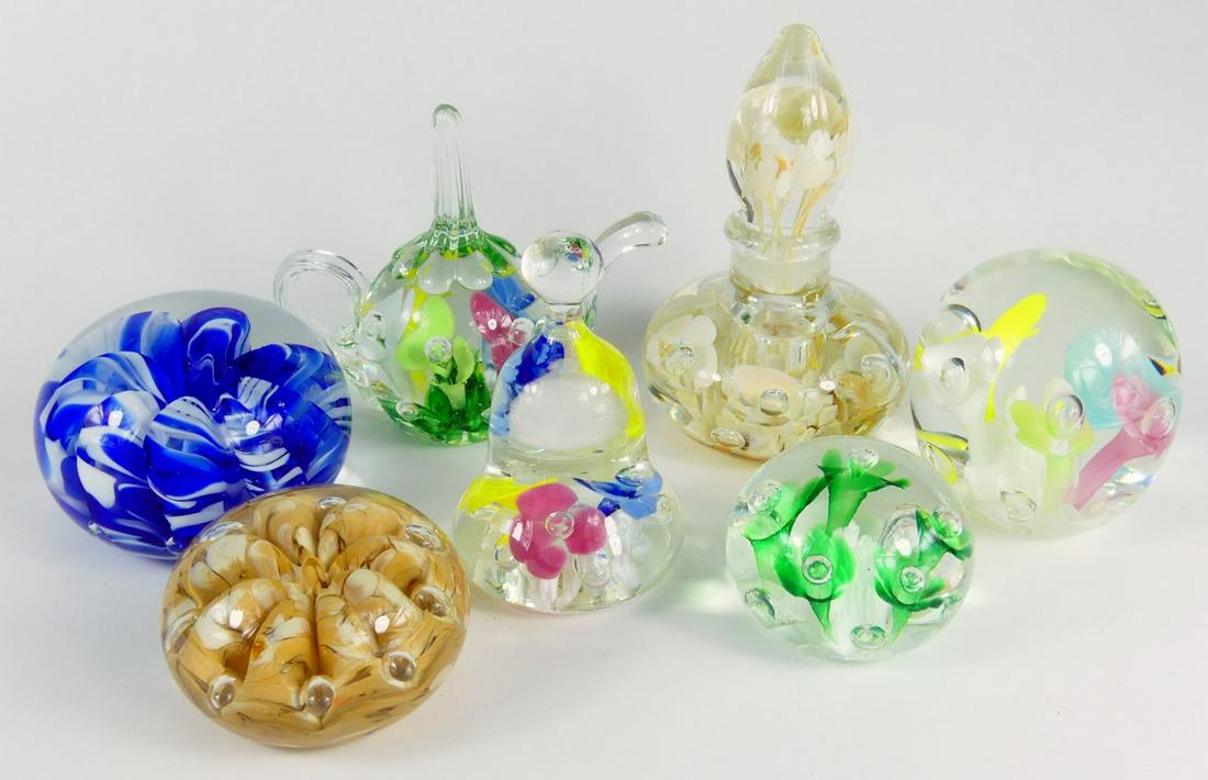 7pc ST CLAIR ART GLASS PAPERWEIGHTS: Seven St Clair family art glass paperweights. Teapot-5 1/2", bell-4 1/8", perfume-5 3/4", cobalt blue-3 1/2" and colorful flowers-3 1/4" are signed Joe. Green-2 1/2" is signed Bob St Clair. Tan-3" is