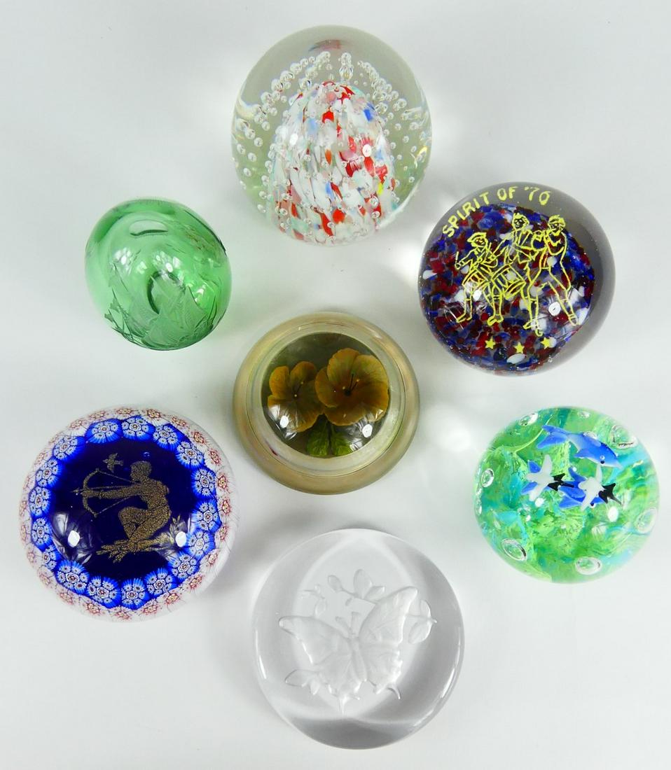 7pc GLASS PAPERWEIGHTS: Seven glass paperweights including Sagittarius, Spirit of '76, Intaglio flower, etched butterfly, etched egg with ship, controlled bubble with ship mark and dolphins. Largest measures 3 1/4" diameter.