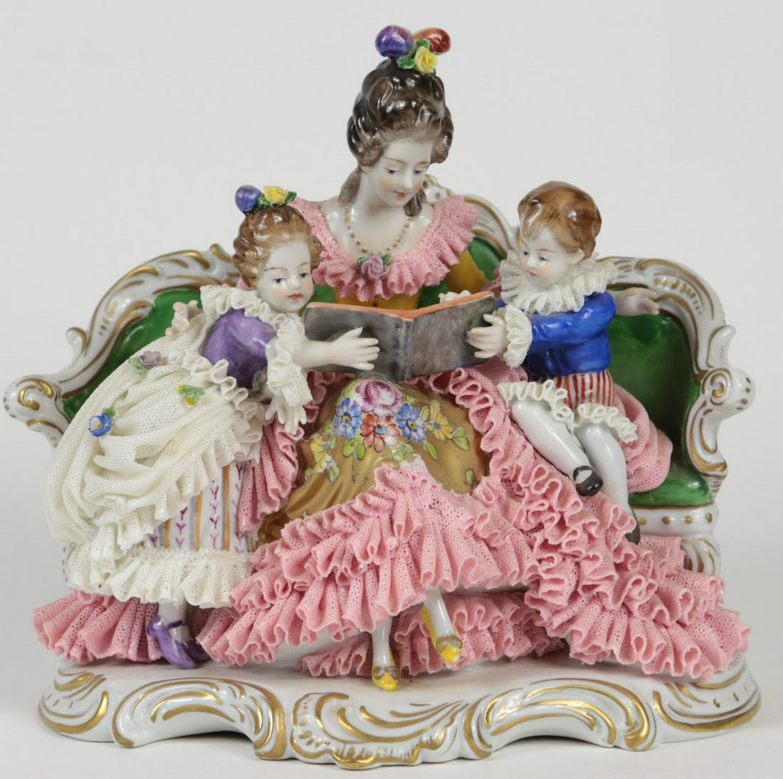 VOLKSTEDT DRESDEN LACE PORCELAIN MOTHER & CHILDREN: Volkstedt Dresden lace porcelain figural grouping depicting a mother reading a book to her two children. Marked to underside. Measures 8 1/2" length x 8" height.