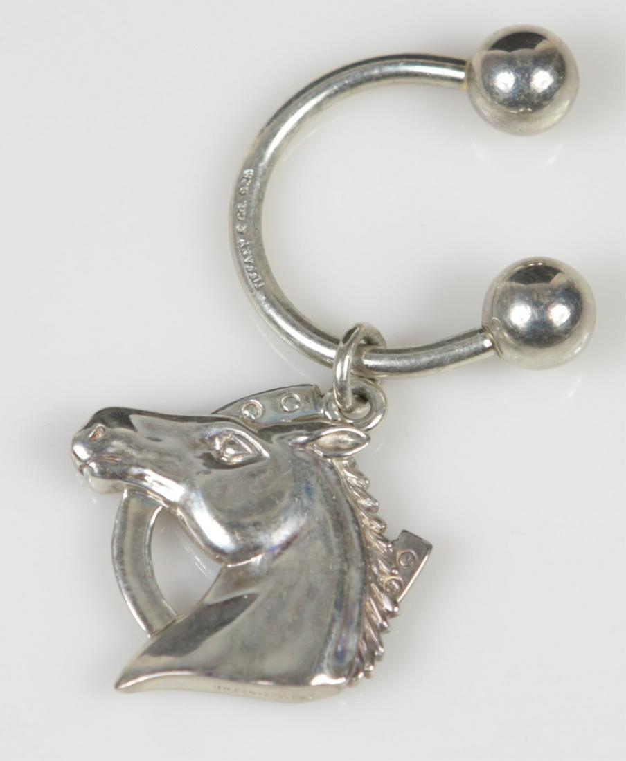 TIFFANY & CO STERLING HORSE / HORSESHOE KEY RING: Tiffany & Company sterling silver keychain having screwball closure and horse charm. Marked Tiffany & Co, 925 to ring and charm. Measures 2 1/2" overall length.