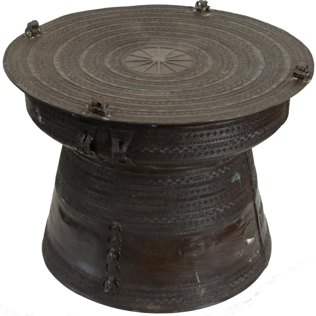 SOUTHEAST ASIAN BRONZE RAIN DRUM: Southeast Asian bronze frog kha rain drum. Circular top features star to center with concentric bands having geometric patterns and four frog form finials. Body is flanked by strap handles and has ban