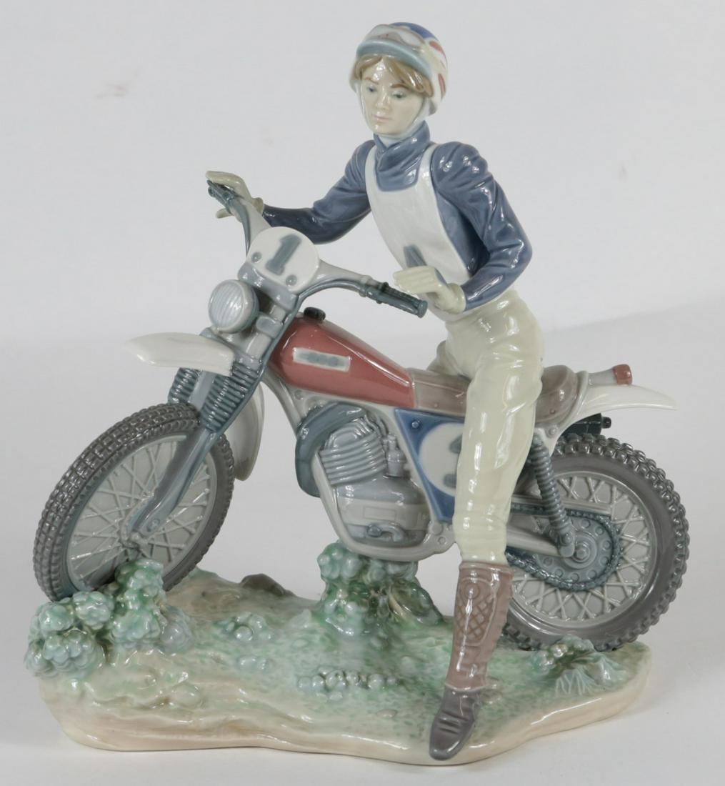 LLADRO RACING MOTORCYCLIST PORCELAIN FIGURINE: Lladro porcelain figure depicting a girl on motorcycle or dirt bike #5270. Marked to underside. Measures 10 3/4" height x 9 3/4" length.