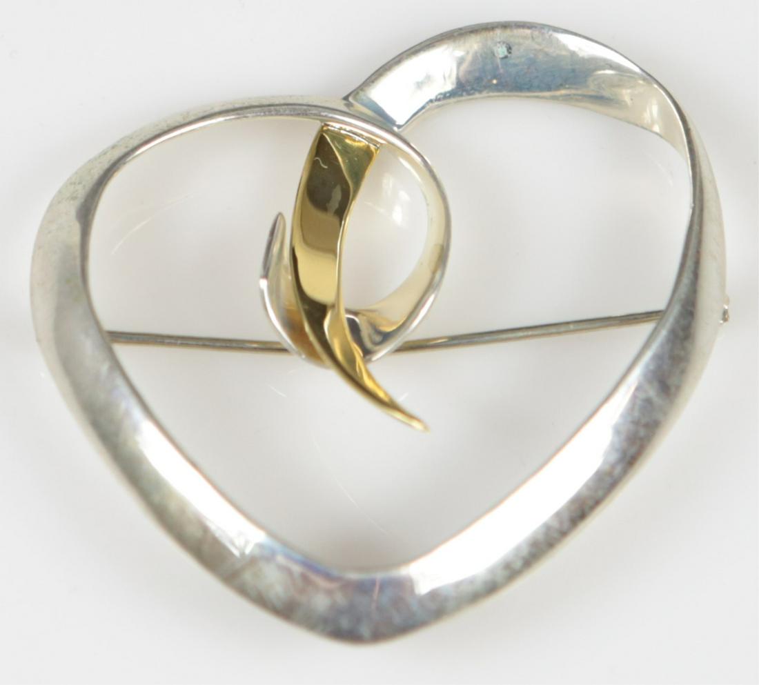 TIFFANY PALOMA PICASSO STERLING 18kt HEART BROOCH: Tiffany & Company sterling silver and 18kt yellow gold brooch in the form of a heart. Marked Tiffany & Co, Sterling, 18K. Signed Paloma Picasso. Measures 2".