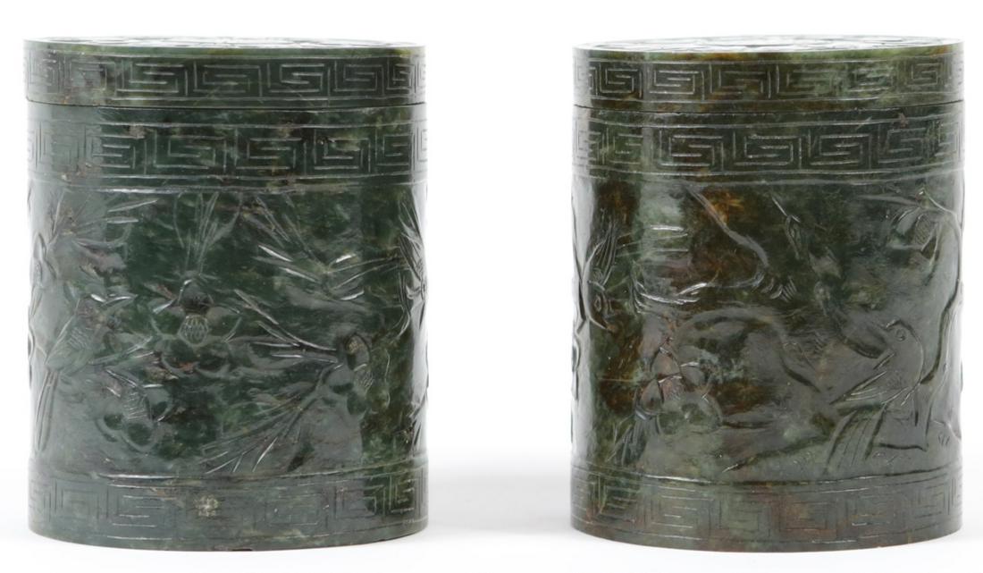PR CHINESE SPINACH JADE COVERED BOXES: Pair of Chinese carved spinach jade covered boxes or jars of cylindrical form. Decorated with birds and flowers. Each measures 3 7/8" height x 3 1/8" diameter.