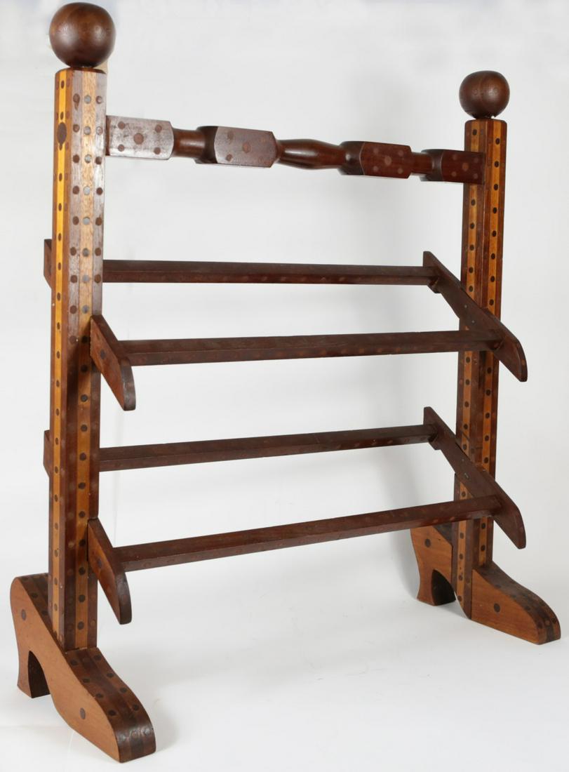 TRAMP ART SHOE RACK: Tramp Art wood shoe rack. Early 20th century. Having two shoe-form feet. Measures 23 1/4" width x 26" height.
