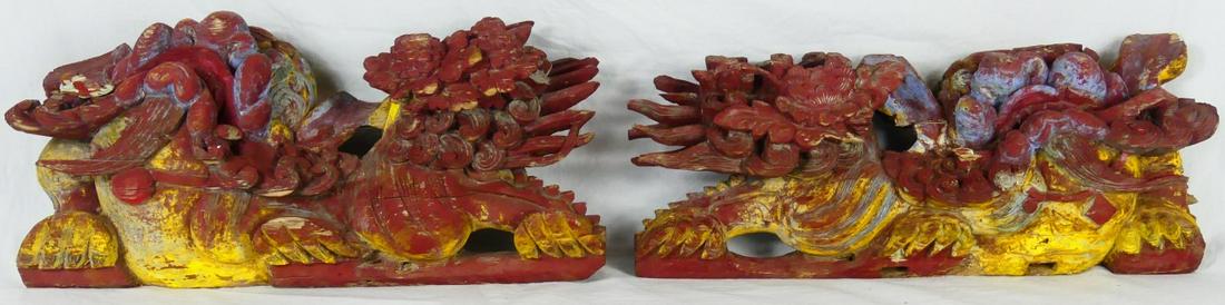 PR CHINESE CARVED ARCHITECTURAL FOO LIONS: Pair of Chinese carved and polychromed wood Architectural foo dogs. These were likely mounted above a doorway to a temple. Each measures 20 1/2" x 9 1/2" height.