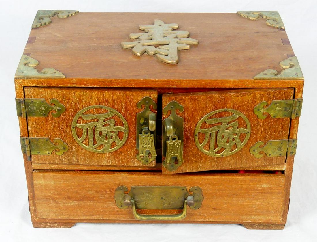 CHINESE WOOD & BRASS JEWELRY BOX: Chinese wood jewelry box with brass mounts and calligraphy symbols. Three drawers to interior. Measures 14" length x 9" height x 8 1/4" depth.