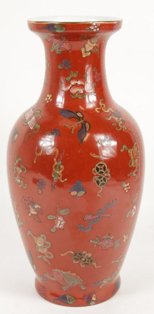 CHINESE RED GROUND FAMILLE ROSE PORCELAIN VASE: Chinese Famille Rose porcelain vase decorated with Buddhist symbols over a red ground. Measures 13 3/4" height.