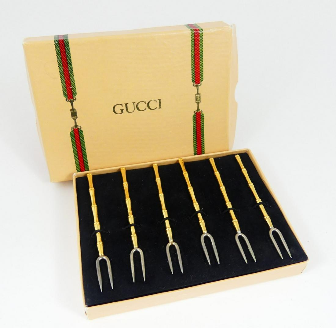 12pc GUCCI DEMITASSE SPOONS & APPETIZER FORKS: Twelve Gucci gold and silver plates demitasse spoons and appetizer forks in Gucci box. Includes six demitasse spoons-3 3/4", each marked Gucci and six bamboo-form appetizer forks-4", unmarked.