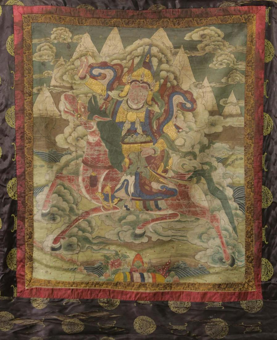CHINESE TIBETAN THANGKA PAINTING GUARDIAN: Chinese Tibetan Thangka painting depicting a guardian on horseback. Painting measures 37 1/2" x 31 1/2". Fabric measures 51" x 42 1/2".