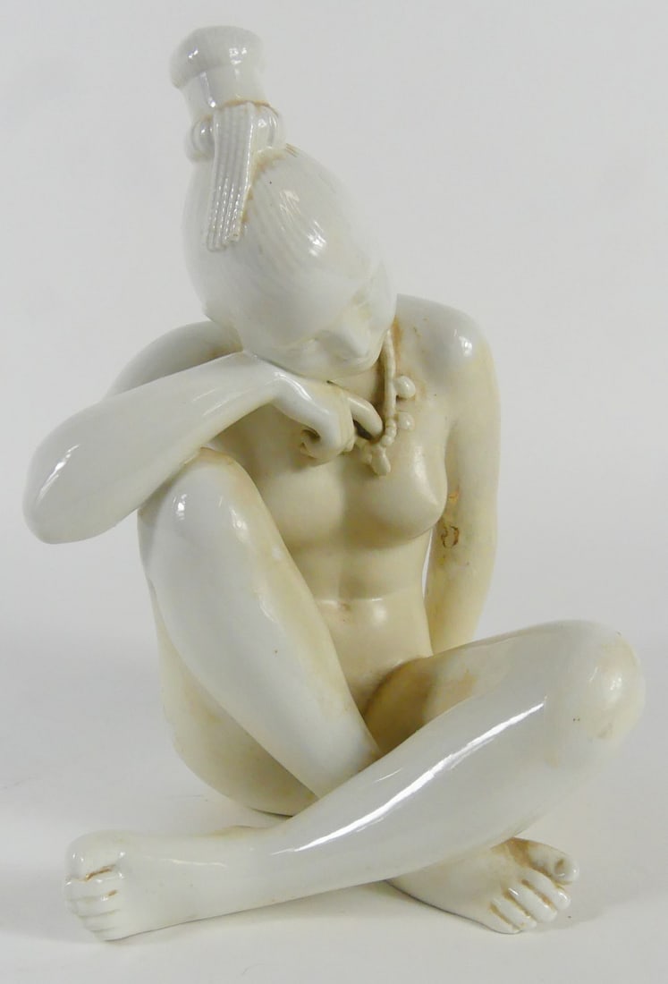 BING & GRONDAHL BLANC DE CHINE NUDE FIGURE: Bing and Grondahl Blanc de Chine porcelain figurine depicting a seated nude female figure. Marked to underside. Measures 9 3/8" height x 7" width. Note: repaired.