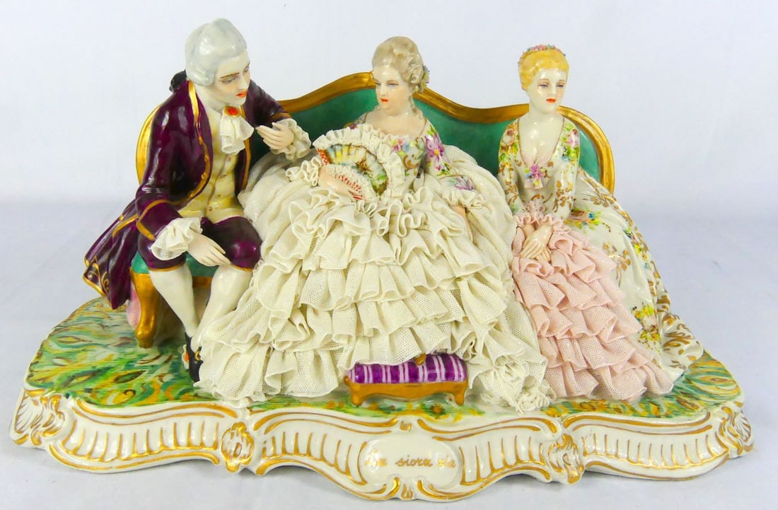 LUIGI FABRIS LACE PORCELAIN FIGURAL GROUP: Luigi Fabris lace porcelain figural group depicting a man and two women seated on a sofa. Marked to verso and to underside. Measures 14 1/2" x 8" x 7".