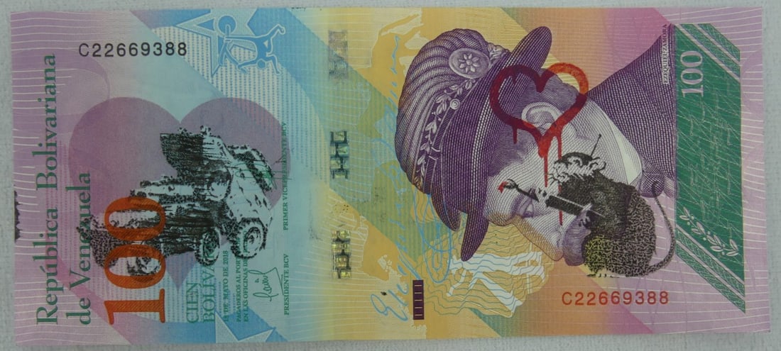 BANSKY DISMALAND VENEZUELAN 100 BOLIVAR NOTE: Bansky Dismaland 100 Bolivar bill. Stamped Banksy. Includes documentation. Note measures 6 1/8" x 2 3/4".