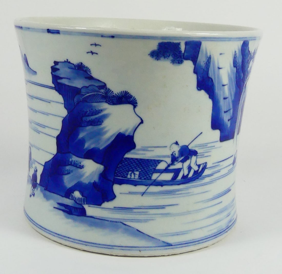CHINESE BLUE & WHITE PORCELAIN BRUSH POT: Chinese blue and white porcelain brush holder of waisted cylindrical form. Decorated with a continuous scene depicting figures in a mountainous river landscape. Marked to underside. Measures 7 3/4" di