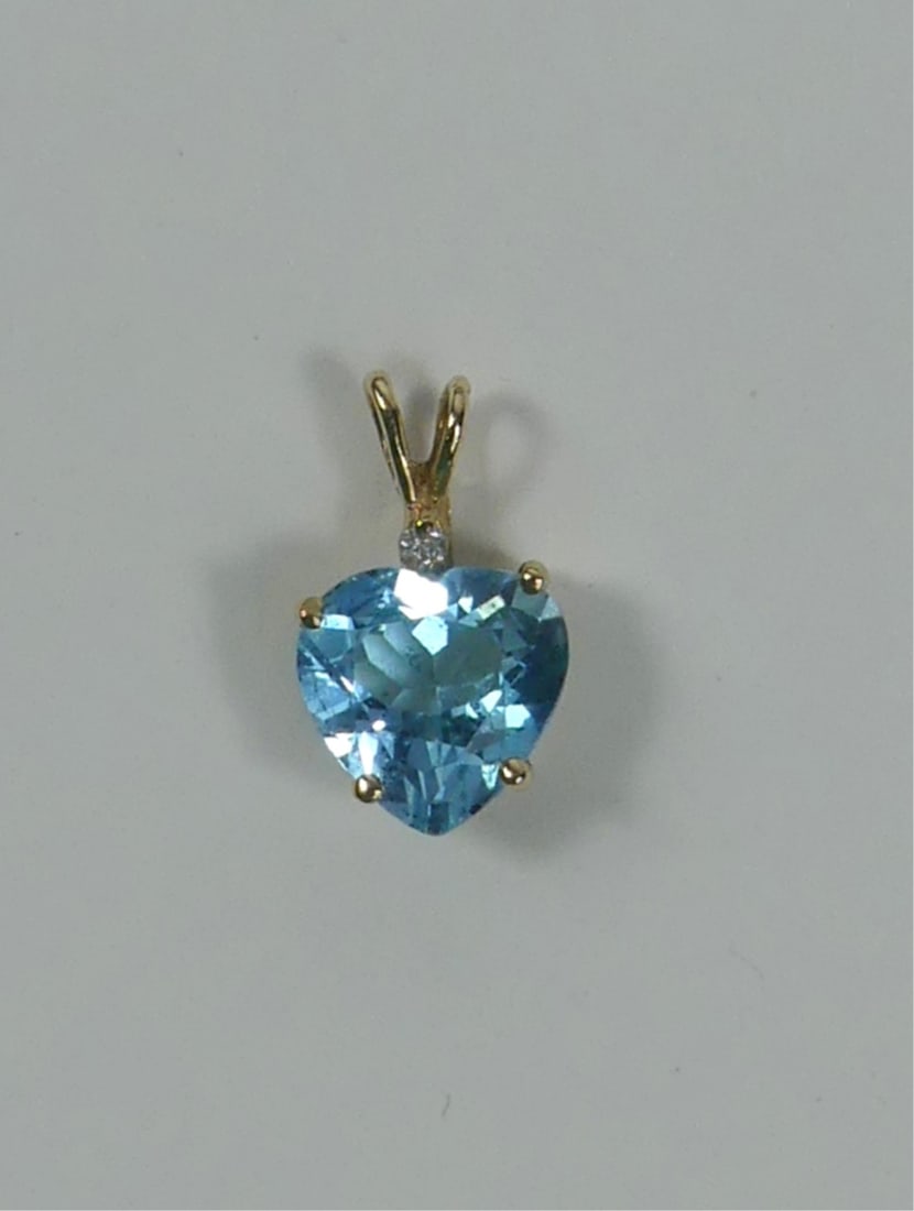 10kt YELLOW GOLD & BLUE TOPAZ HEART PENDANT: 10kt yellow gold and blue topaz heart pendant. Marked 10k. Measures 17mm including bail. Total weight 1.6g.
