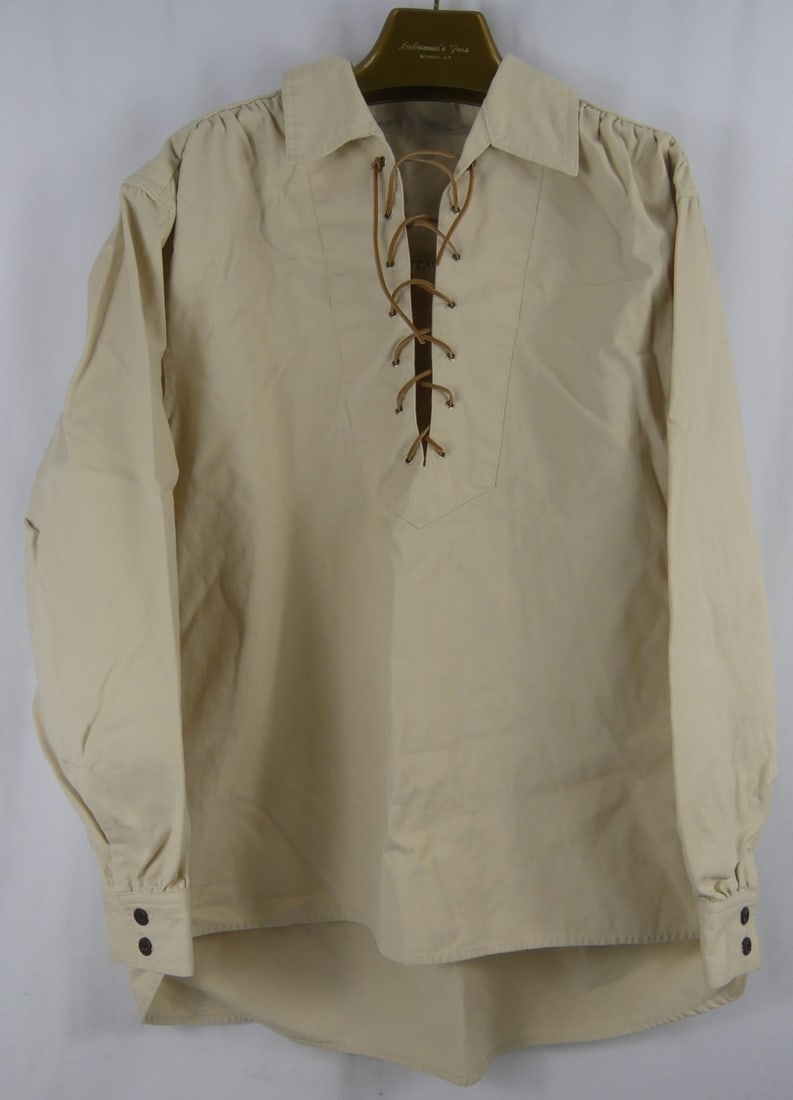 ELVIS PRESLEY OWNED TAN LONG SLEEVE SHIRT: Elvis Presley owned tan long sleeve shirt having collar and leather rope closure. Measures approx 34" length x 28" wide. Includes hand signed letter from Vernon Presley.