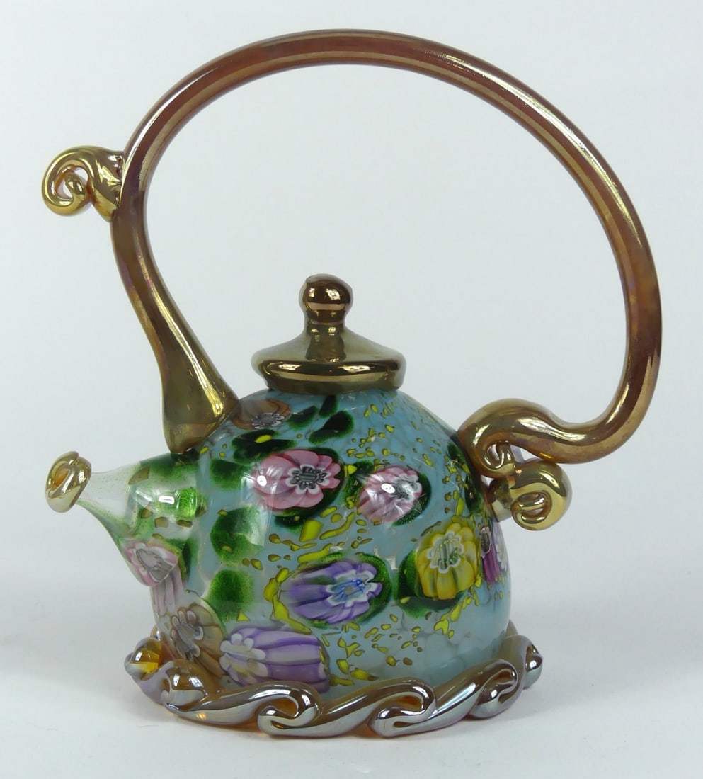 PAUL ALLEN COUNTS ART GLASS TEAPOT: Paul Allen Counts studio art glass teapot with caned decoration and gold-tone trim. Signed to underside. Measures 9"h x 8" l" x 5" w.