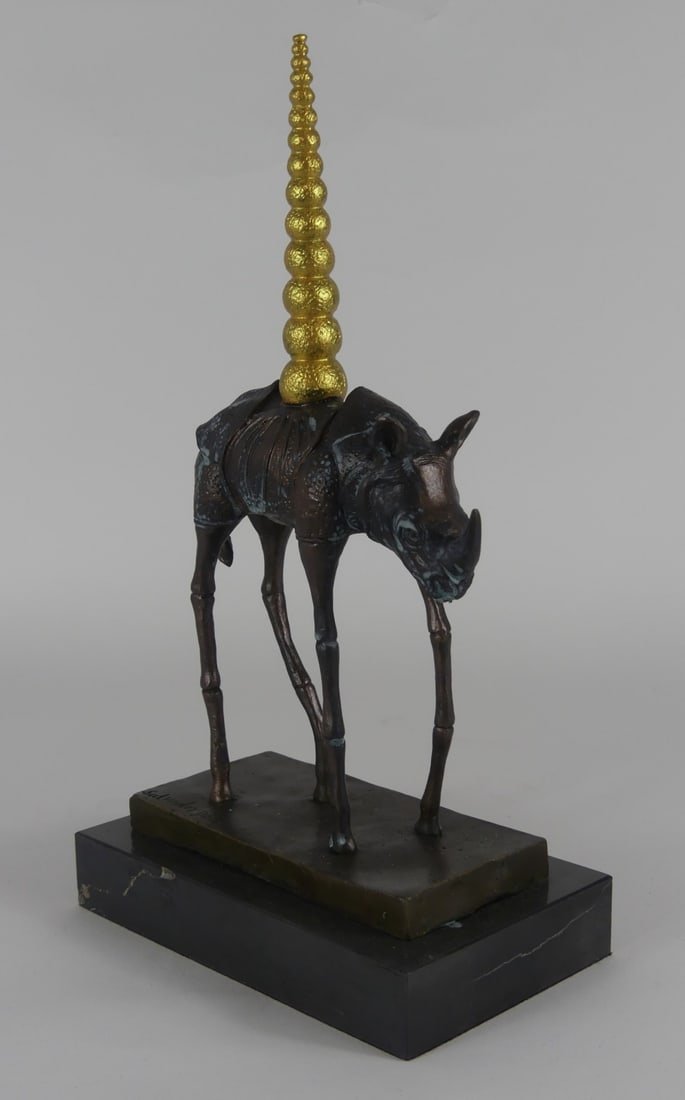 SALVADOR SALI 'COSMIC RHINO' BRONZE SCULPTURE: Bronze sculpture depicting a rhinoceros with elongated legs titled 'Rhinoceros Cosmique' after Salvador Dali. Signed to bronze base. Mounted to marble plinth. Measures 13 1/4" x 7 1/2" x 4 1/2".