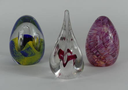 3pc ART GLASS PAPERWEIGHTS: Three art glass paperweights including Jablonski tear drop shape, Tidal Wave Glass egg and unsigned blue and yellow egg with label. Largest measures 5" x 2 1/2" x 2 1/2".
