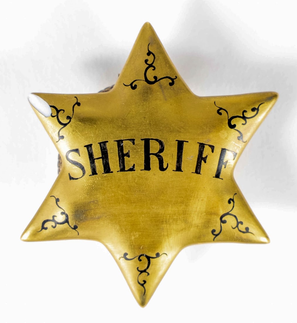 LIMOGES 'SHERIFF' STAR PORCELAIN TRINKET BOX: Limoges porcelain trinket box in the form of a six point Sheriff badge. Marked to underside. Measures 2 1/2" x 2 1/4" x 3/4". Note: chip to one point.
