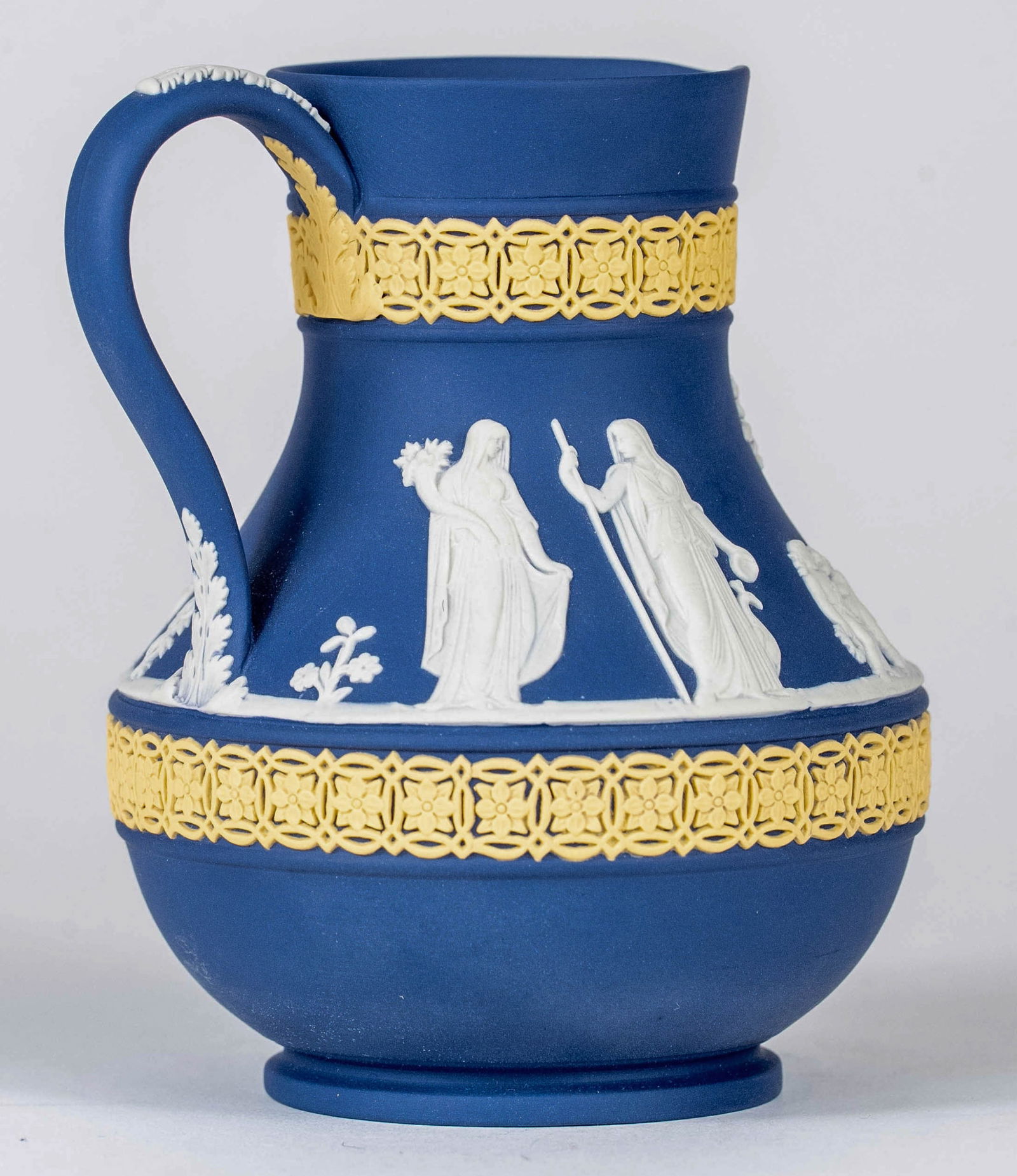 WEDGWOOD TRICOLOR JASPERWARE ETRUSCAN JUG: Wedgwood tri-color jasperware Etruscan jug / pitcher. Marked to underside. Measures 4 3/4" x 4 3/4" x 3 3/4".