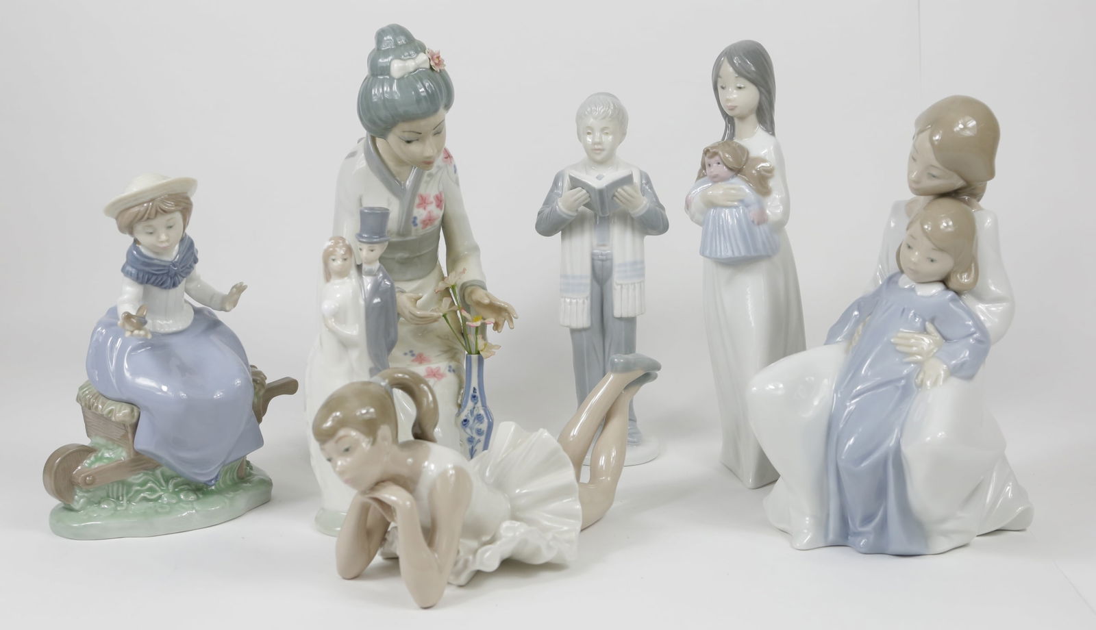 7pc LLADRO STYLE PORCELAIN FIGURINES: Seven porcelain figures including Nao Wedding Couple, Nao Girl with Doll. Nao Girl with Bird, Nao Reclining Ballerina, Nao Mother & Child, Japanese Geisha and Japanese Hebrew Student. Each marked to u