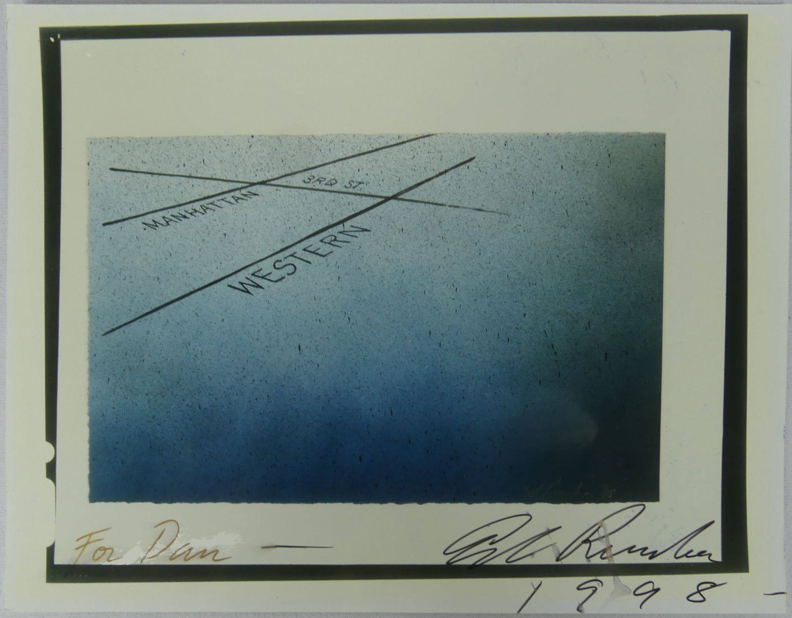 ED RUSCHA MANHATTAN/3RD/WESTERN SIGNED PHOTOGRAPH: Ed Ruscha glossy photograph depicting Manhattan, 3rd St and Western. Signed and dated 1998 in black marker lower right. Gallery label to verso. Sheet measures 11" x 8 1/2".