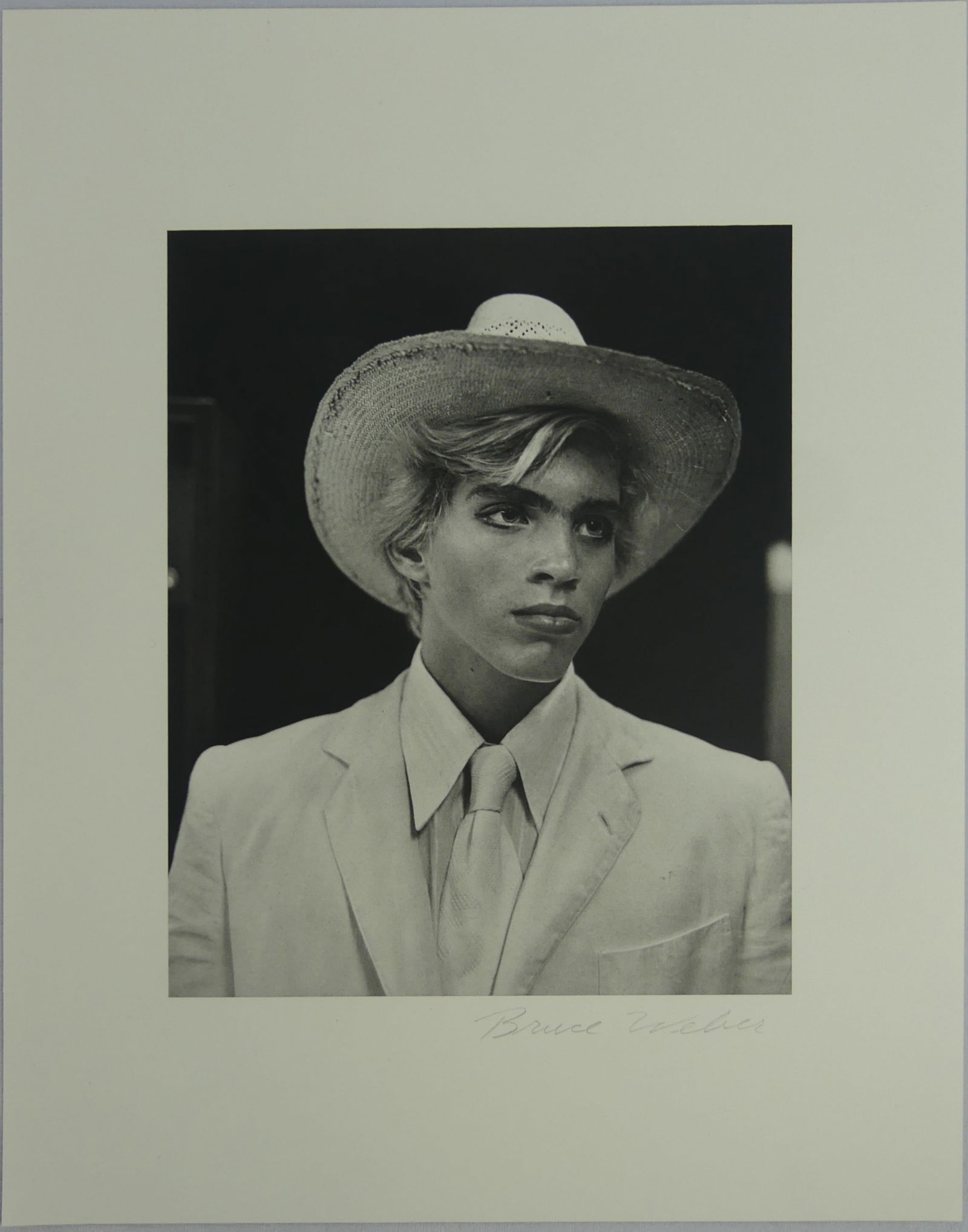 BRUCE WEBER 'YOUNG MALE COWBOY HAT' SIGNED: Bruce Weber photo lithograph depicting a young male in suit and cowboy hat. Pencil signed lower right. Sheet measures 14" x 10 3/4".