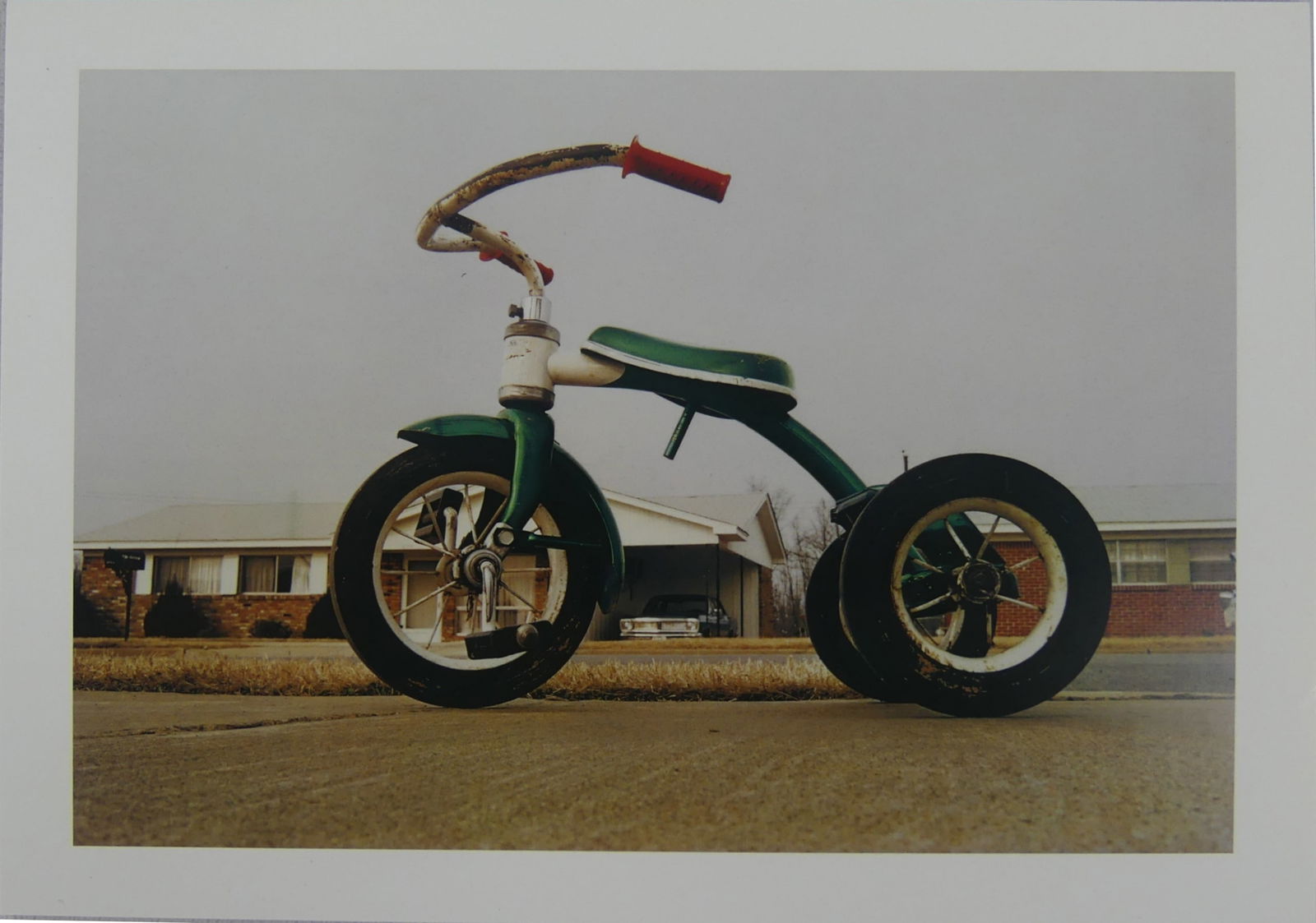 WILLIAM EGGLESTON 'TRICYCLE' PHOTOGRAPH: William Eggleston 'Tricycle' photo print. Mounted. Measures 8 3/8" x 5 7/8".
