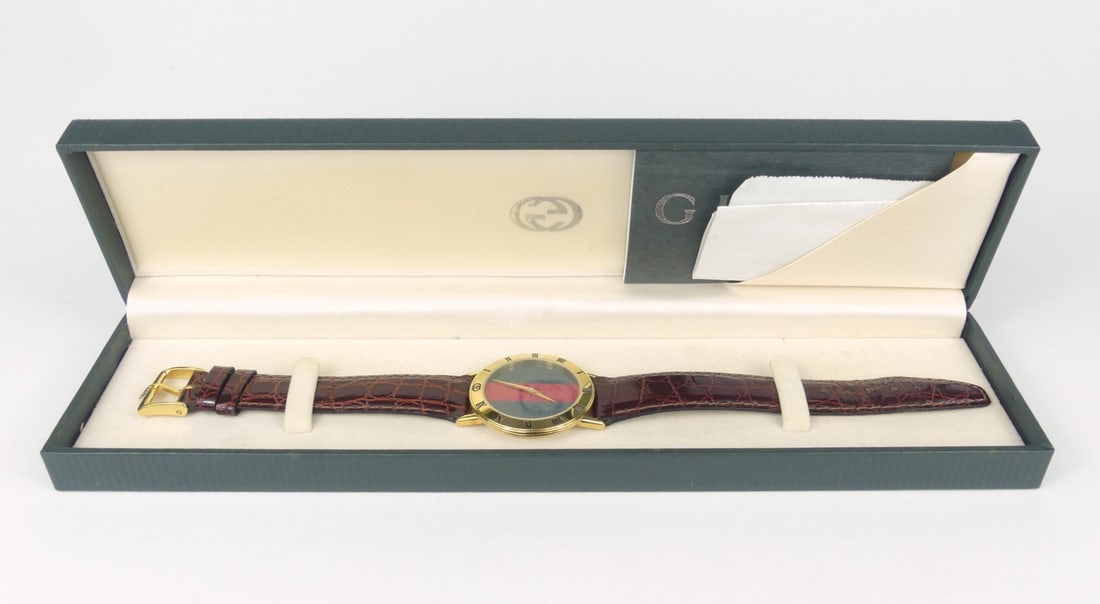 GUCCI 3000.2M WRISTWATCH w BOX: Gucci 3000.2m Quartz wrist watch. Original crown and Gucci strap clasp. Includes original box and papers. Case measures 33mm width x 39mm lug to lug. Box measures 10" x 2 1/2" x 1 1/4".