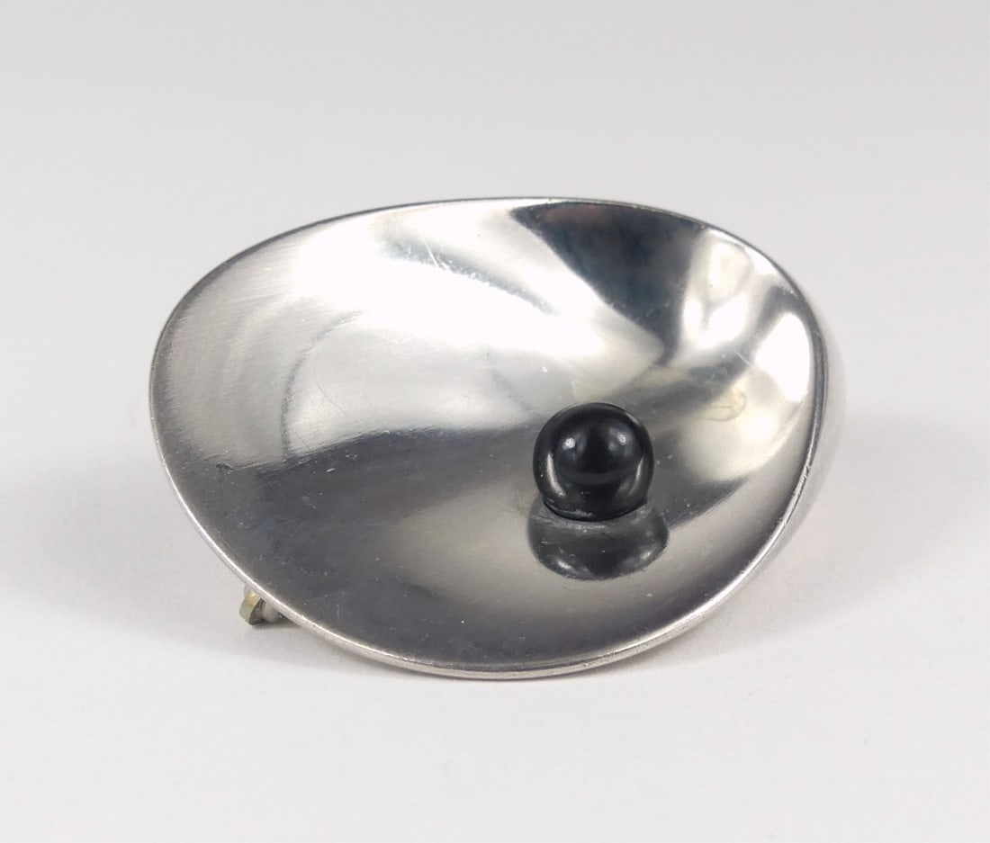 GEORG JENSEN STERLING & ONYX BROOCH: Georg Jensen sterling silver oyster shell brooch with onyx pearl. Designed by Nanna Jurgen Ditzel. Marked to underside. Brooch measures 2" x 1 5/8". Total weight 24g.