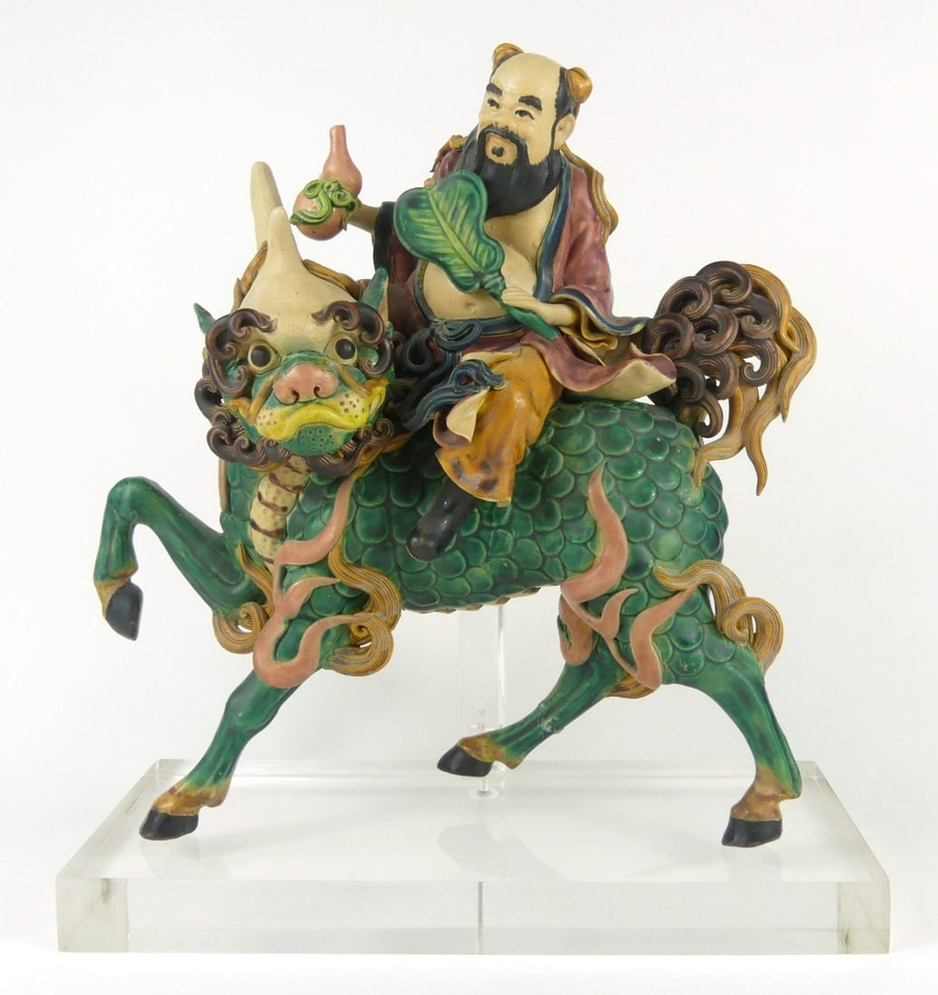 CHINESE POLYCHROMED CERAMIC ROOF TILE: Chinese glazed ceramic roof tile depicting an Immortal with fan and double gourd on the back of a mythical beast. Ceramic measures 12 1/4" height x 11 1/2'. Measures 13 1/2" x 12" x 5" overall with ac