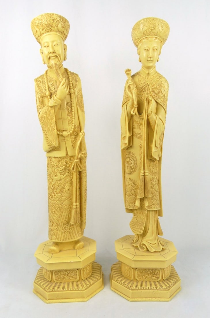 PR CHINESE CARVED EMPEROR & EMPRESS SCULPTURES: Pair of Chinese carved faux ivory resin sculptures depicting an Emperor and Empress. Each raised on octagonal base. Each measures 21 5/8" x 6" x 5 1/2".
