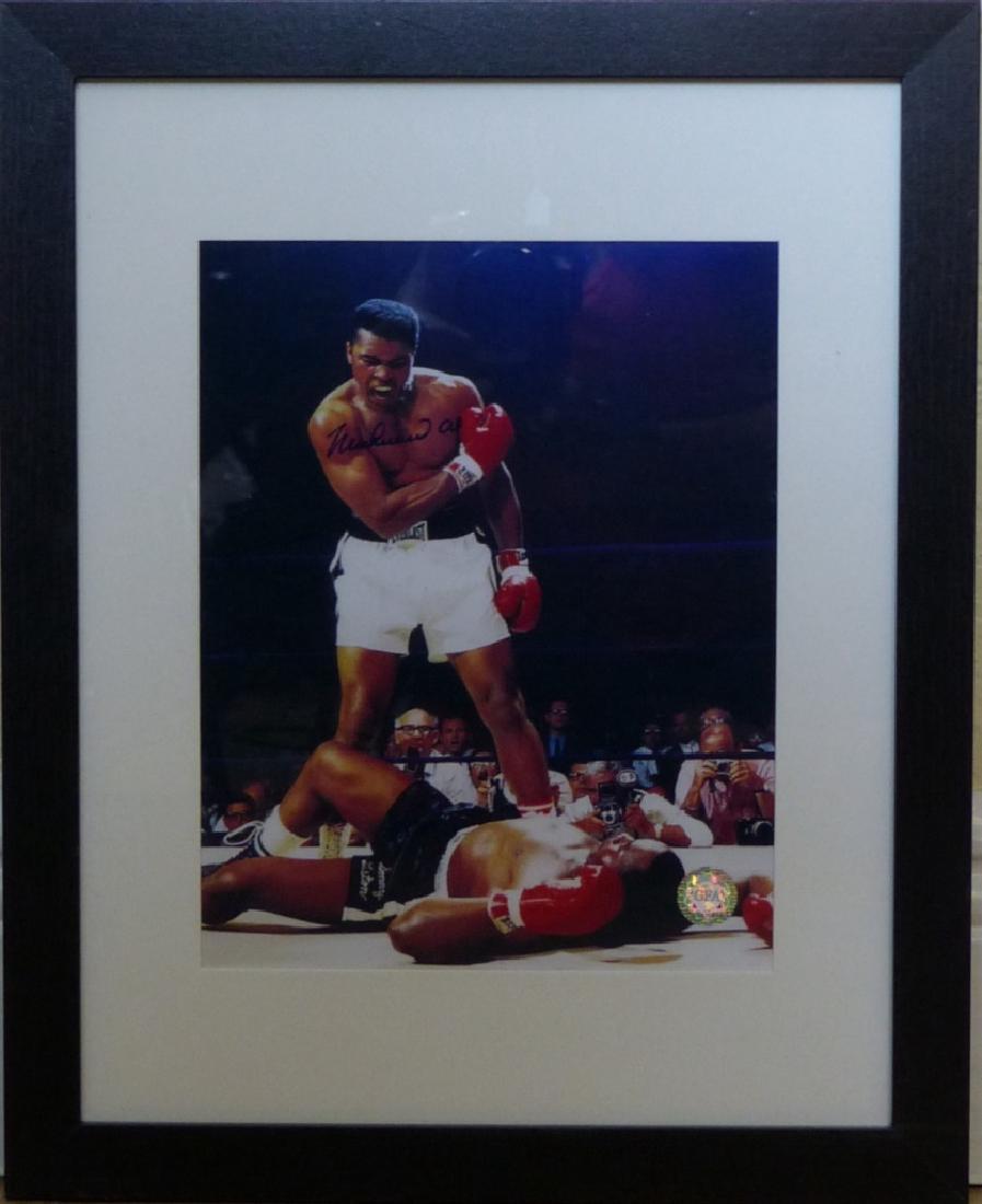 MUHAMMAD ALI AUTOGRAPHED FRAMED PHOTOGRAPH w COA: Muhammad Ali autographed framed picture. Includes GFA certificate of authenticity. Measures 9 1/2" (24cm) height by 7 1/2" (19cm) width plus 3" (8cm) frame and matting.
