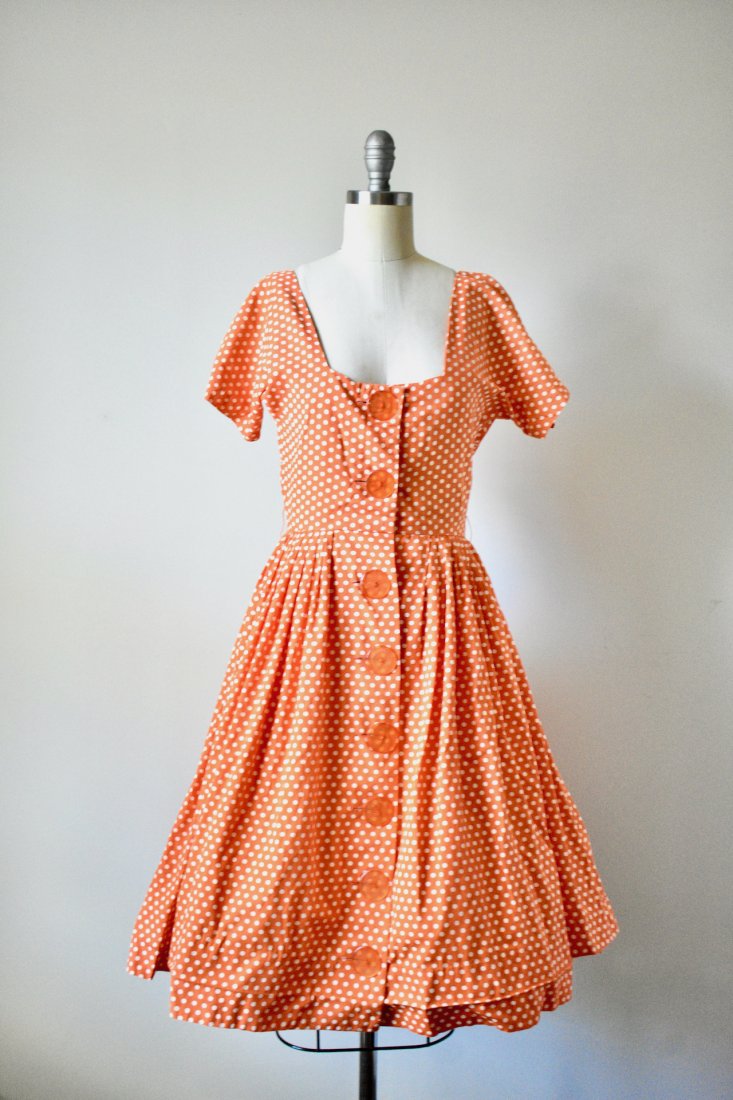 Vintage 1950s Orange Polka Dot Novelty Day Dress by: Vintage 1950s Orange Polka Dot Novelty Day Dress by Dress Town INC. Excellent condition with minor wear. Beautiful orange buttons to button down for closure. Flared skirt. Fitted waist. Labeled.