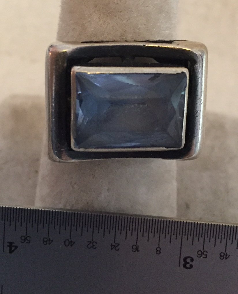 Silver w/ Blue Spinel Ring: 15 x 10 mm blue spinel cushion-cut stone. Marked 925. Shank is broken in back. 10 grams total weight. Size 8.5.
