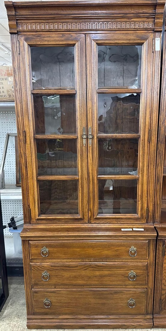 Ethan Allen wooden shelf unit: Top and bottom are not attached. There glass pane doors with three adjustable glass shelves on top and three drawers below. 210 wide by 14 deep x 68 tall. Lighted. Wavy glass.
