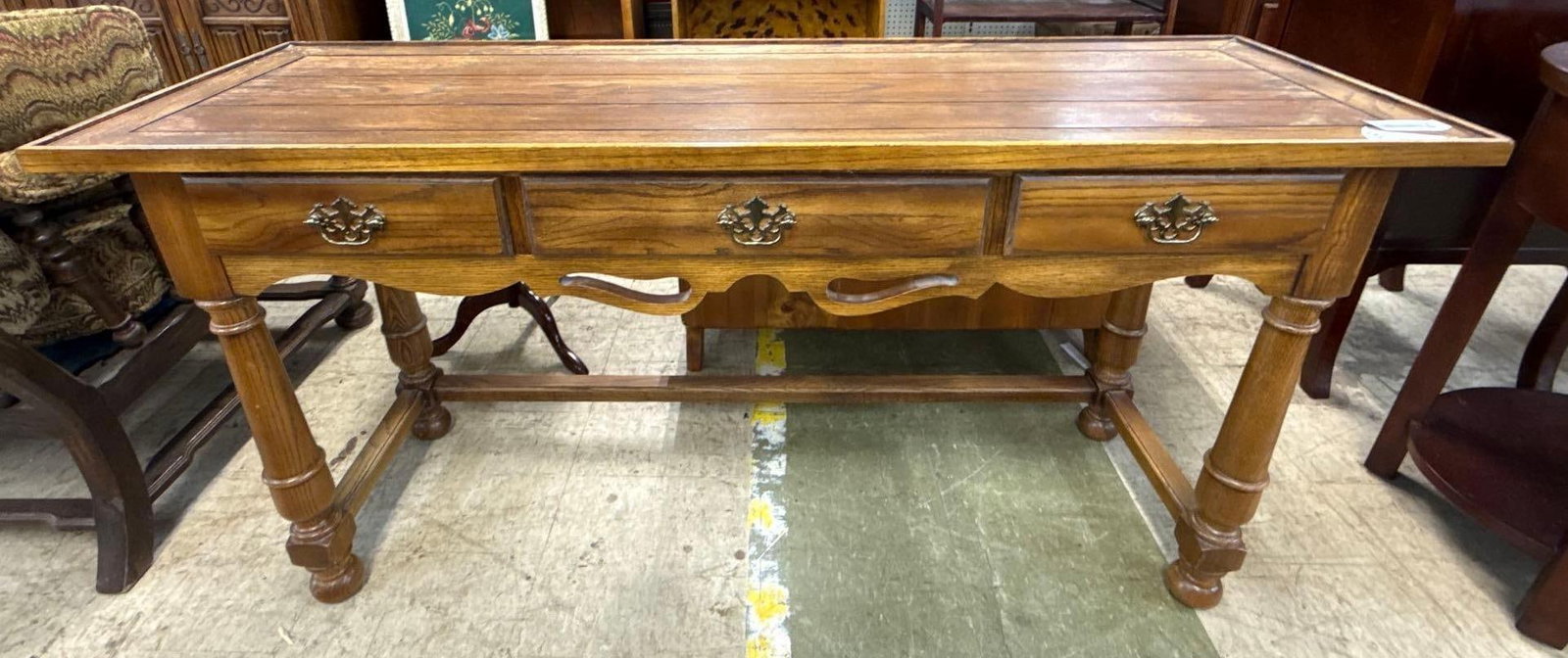 Oak living room table with three drawers: Ornate brass handles. 54 inches wide by 17 inches deep by 27 inches tall.