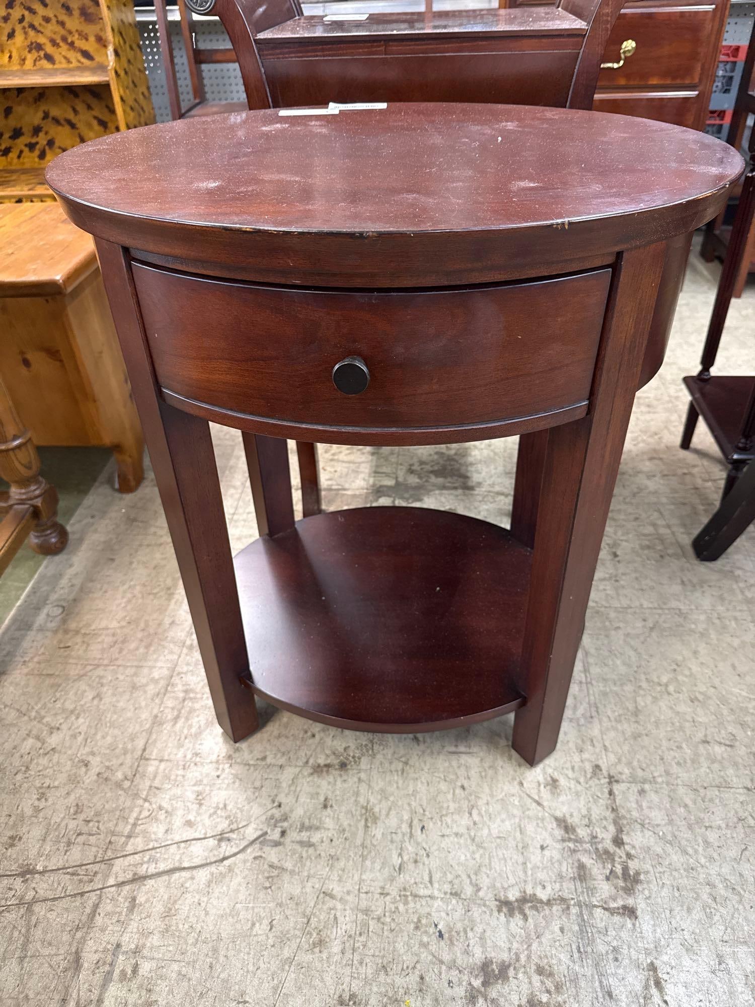 mahogany oval side table: One curved drawer, and lower shelf. 2 feet wide by 20 inches deep by 27 1/2 inches tall.