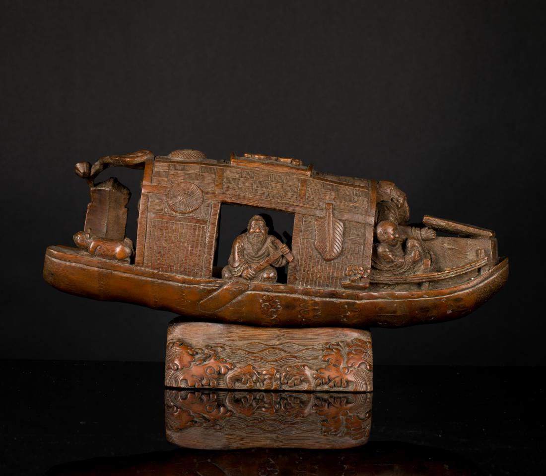 Late 19th Antique Carved Bamboo Figural Ship: Worked in the form of a flat-bottomed boat on a bed of swirling waves, the bow covered with an arched woven roof and the mast folded on the side, with a paddle stick leaning diagonally against the roo