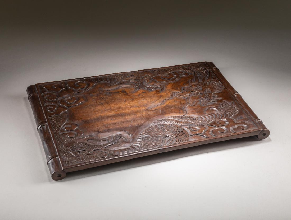 19th Japanese Antique Wood Tea Stand: Of rectangular form, support on a scrolling feet, the surface carved in low relief, depicting one sinuous dragon twisting, corner decorated with cloud scroll. 17.5 inch L; 0.6 inch H