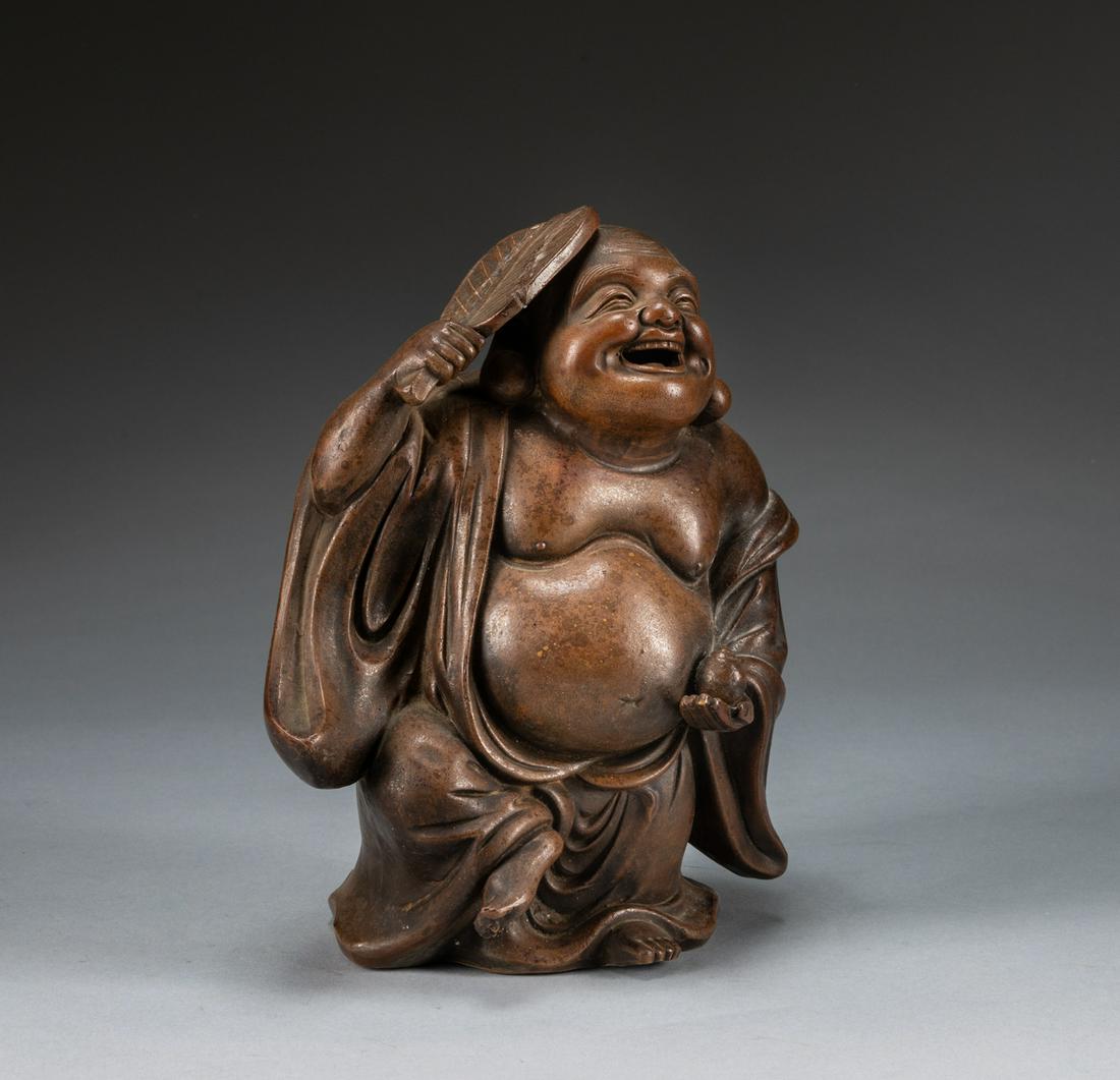 REPAIRED Japanese Antique Zisha Buddha: The buddha seated with right leg drawn up to support his resting right hand raised grasping a fan, the left hand holding a case, his flowing robes left wide open to reveal his swollen belly and protru