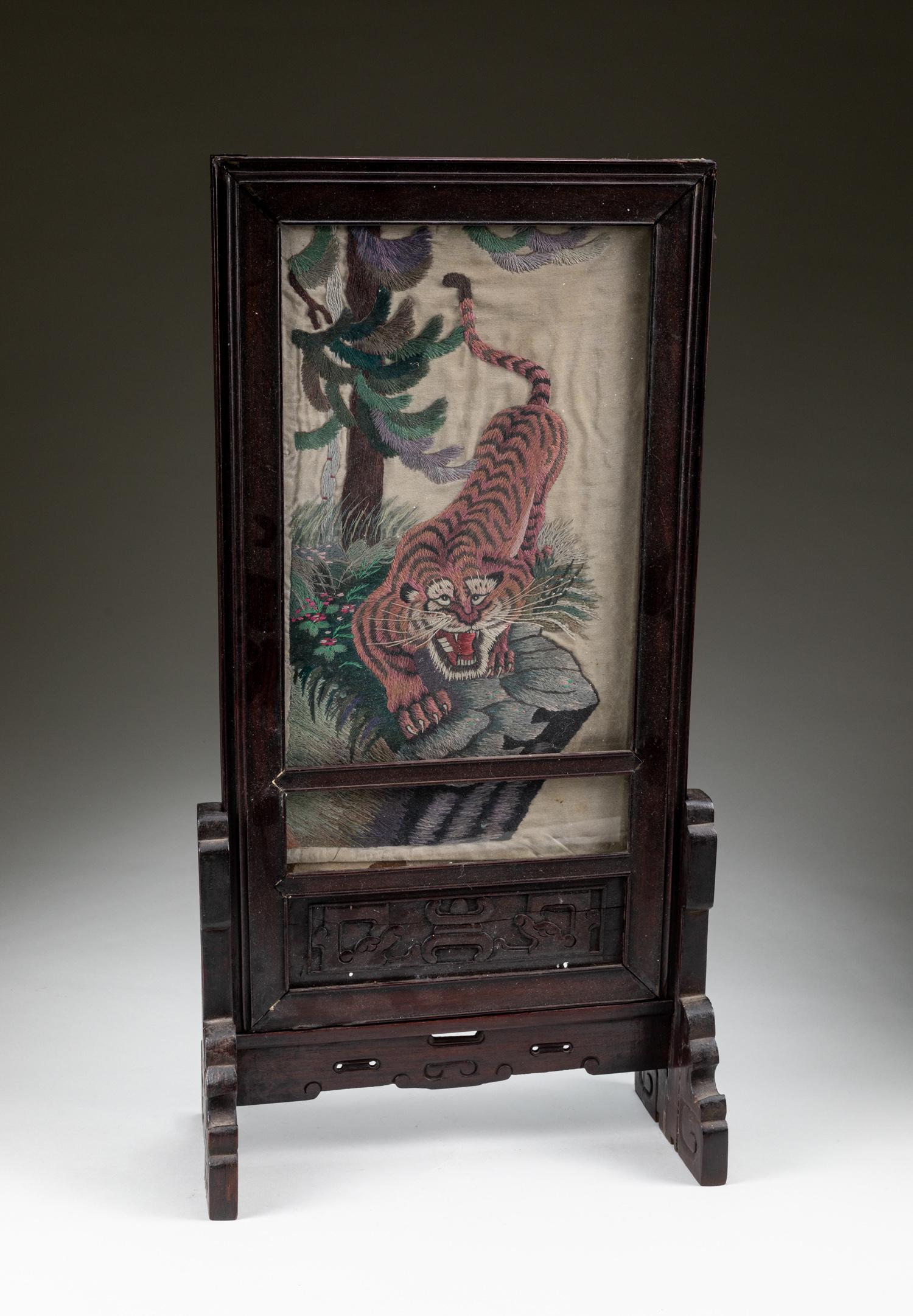 19th Chinese Antique Silk Tiger Screen: The silk painted with a central figure of crouching tiger, all enclosed within a wood frame, the wood stand with a pair of upright supports, and the base raised on shaped trestle feet. Approximately 2
