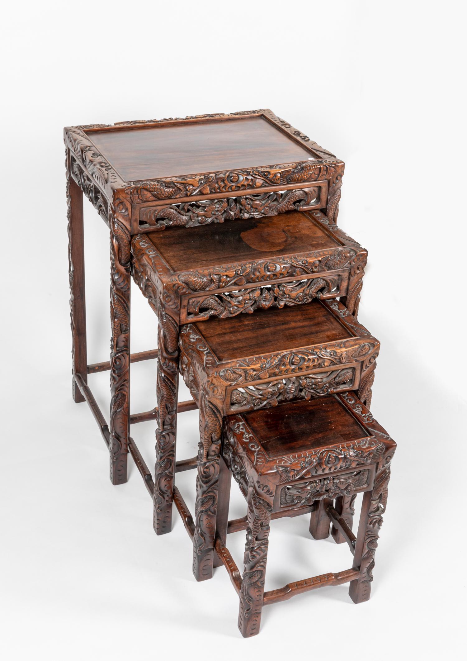 Set Of Four Chinese Rosewood Nesting Table-Form Stands: Each carved in an openwork depicting a pair of scaly dragons confronting a â€œflaming pearl”. 19.5*28*14 inch (largest)
