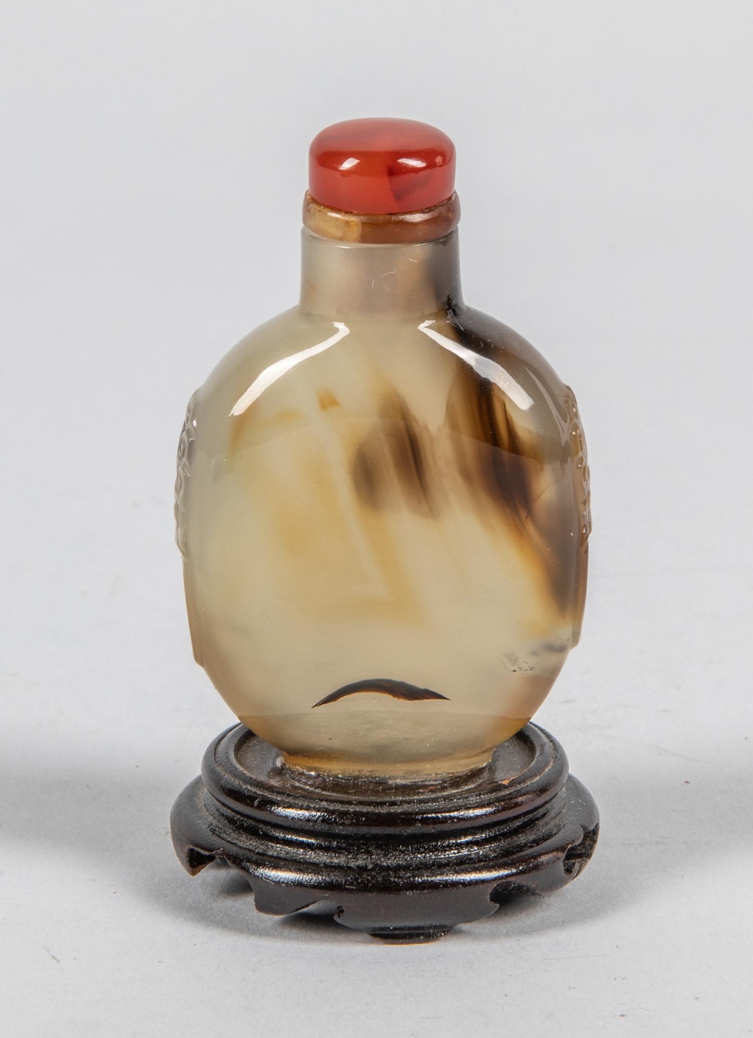 Chinese Cameo Agate Snuff Bottle: Antique and finely hollowed, Chinese cameo agate snuff bottle; the flattened form, banded brown inclusions throughout, 3 inch H. (with wood stand). 1.6 inch W.