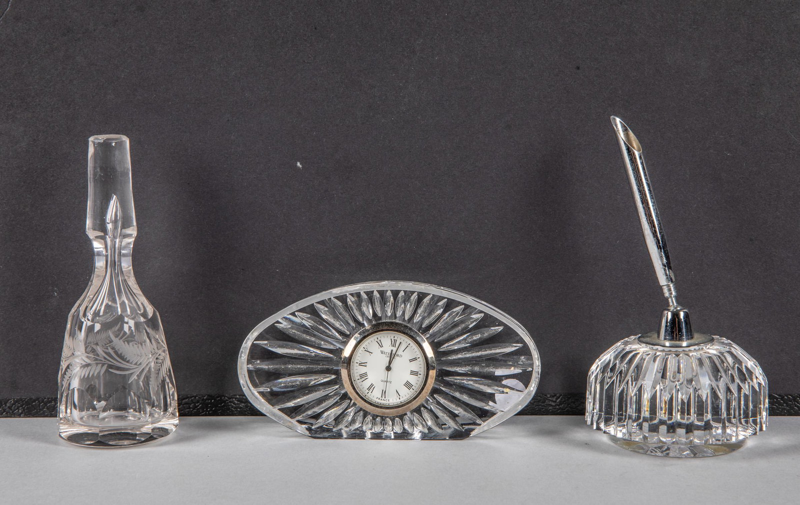 Set Waterford Crystal Items: Group of three carved crystal glass wares, including a water ford table clock, a carved stopper & a stands. Minor chips. 2.5-4.75 inch.